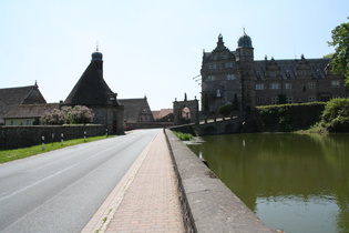 Schloss Hämelschenburg: links Schlossgebäude und Teich, rechts Wirtschaftsgebäude und Kirche