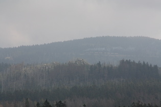 der Quitschenberg mit seinen Klippen, im Hintergrund stinkt ein dampfbespannter Zug auf den Brocken