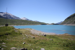 Blick über den Lago di Monte Spluga auf den zweiteiligen Staudamm mit integriertem Felsen in der Mitte