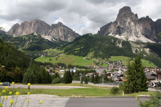 Blick über die Nordrampe des Passo di Campolongo auf Corvara, dahinter v. l. n. r.: Sas Ciampac, Sas Ciampei und Sassongher