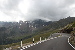 Blick über die oberste Kehre der Südrampe ins Val Malza und zur Punta di Pietra Rossa (Gipfel in Wolken)