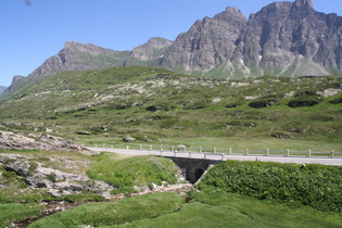 Führung der Passstraße über eine alte Steinbrücke über den Maseggbach, im Hintergrund v. l. n. r.: Tempahorn und Piz Uccello